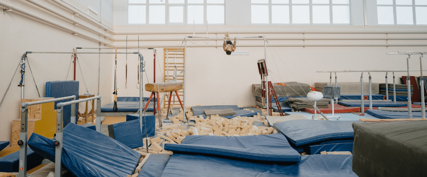 Gimnasio de entrenamiento con barras, colchonetas y fosa de espuma